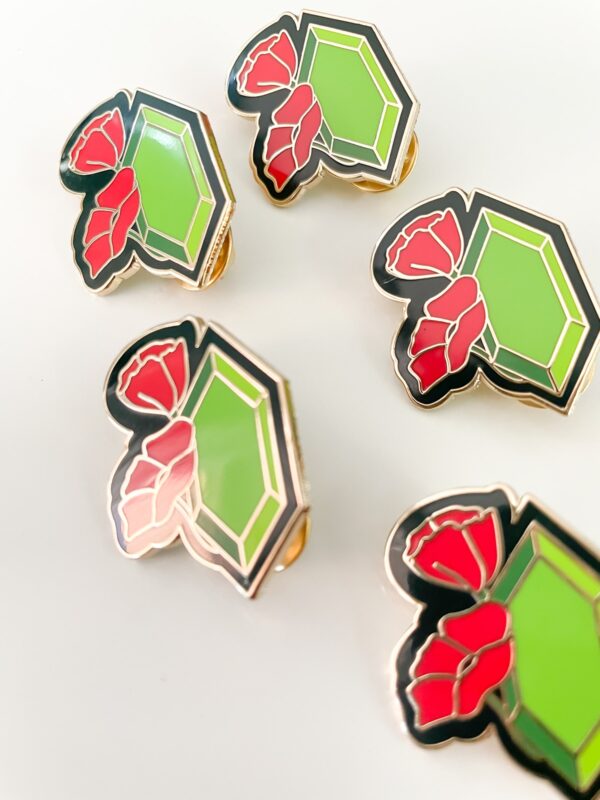 Gold enamel pin for August babies. Peridot and red poppy flower in gold enamel pin.