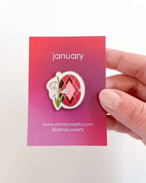 Garnet Birth month pin with red stone and white snowdrop flower.