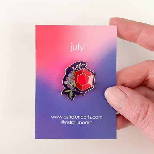 July Birth Month pin with ruby stone and larkspur flower with pin and purple card backing by astraluna arts