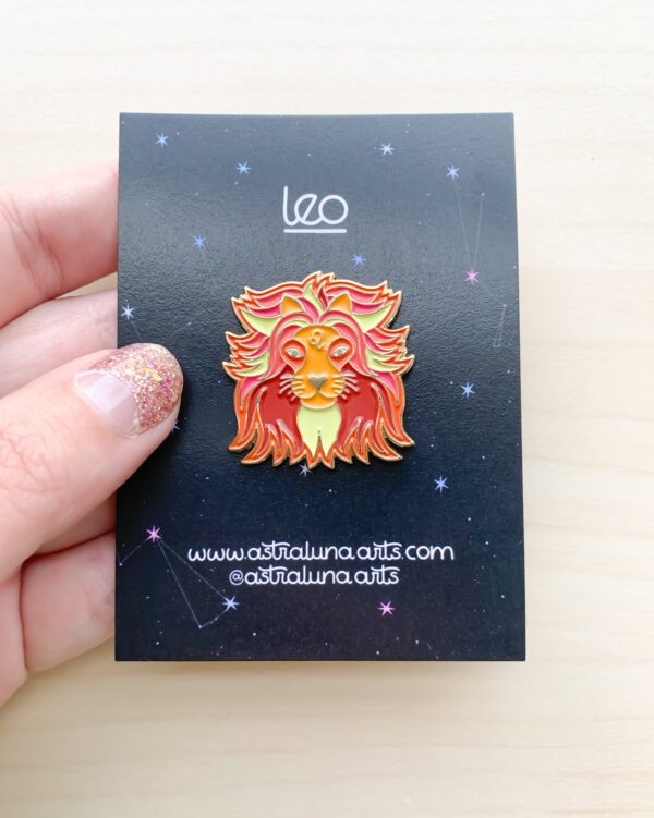 Leo Pin featuring lion symbol with orange and yellow mane in gold enamel.