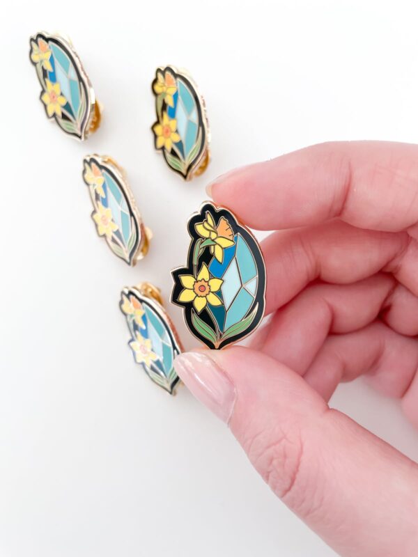 April pin featuring aquamarine and daffodils.