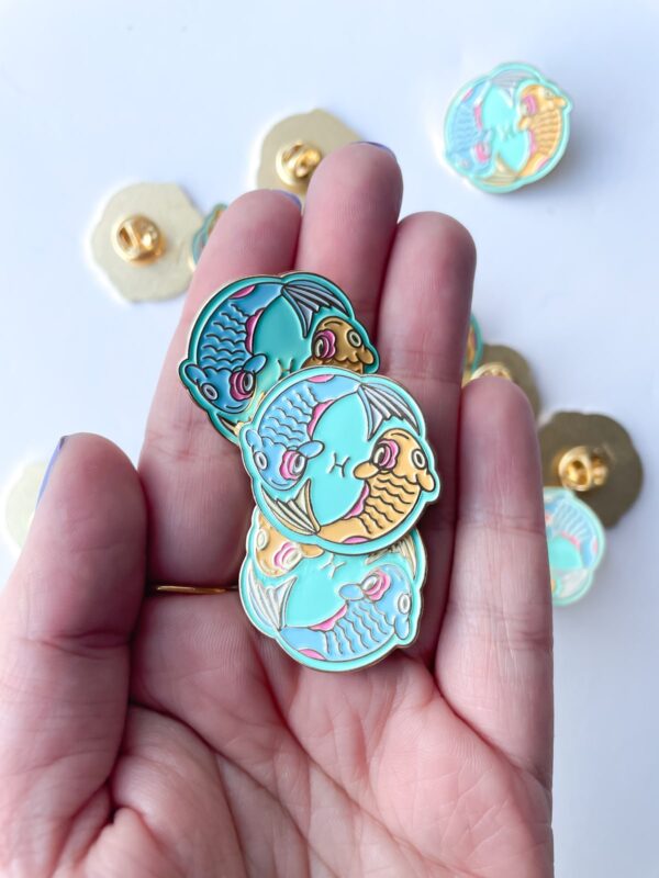 Pisces symbol Pin with blue and gold fish.