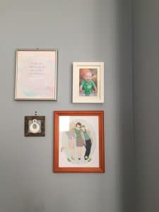Custom prints on gray wall with brown frame.
